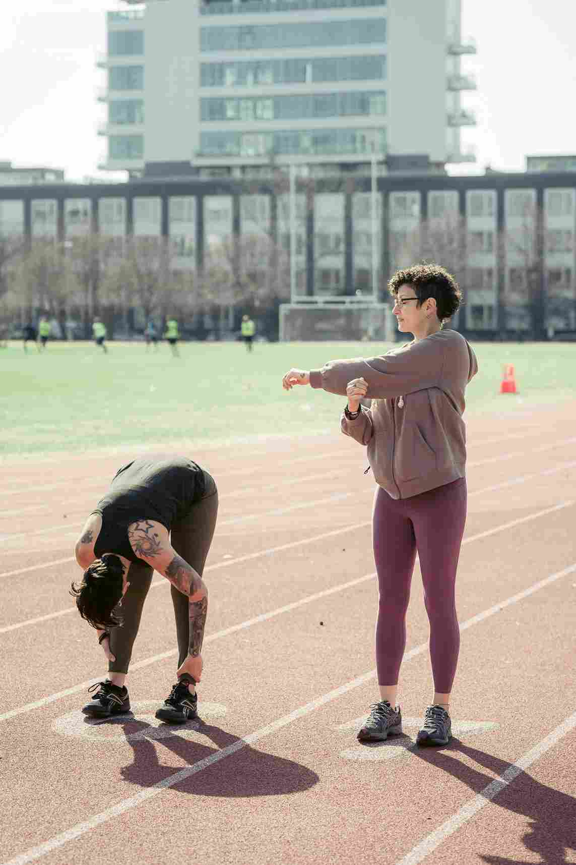 Active sportswoman stretching before running in a stadium